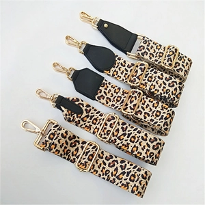 Detailed view of adjustable leopard print canvas bag straps with gold hardware and leather ends