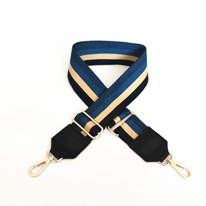 Détail de la bandoulière réglable en toile rayée avec des fermoirs mousquetons dorés