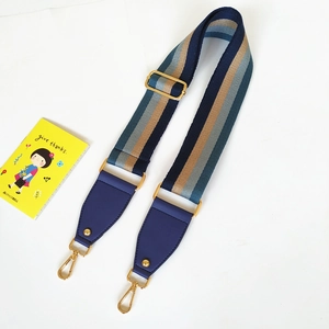 Detail of adjustable wide striped strap with golden hardware and leather connector