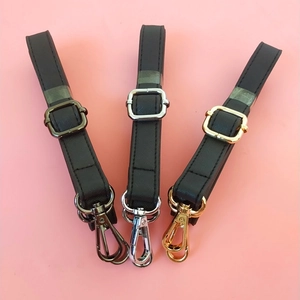 Detail showing black Saffiano faux leather straps with gold, silver, and gunmetal buckles