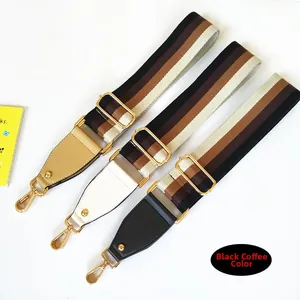 Detailed view of adjustable wide canvas guitar style straps with gold metal hooks and leather