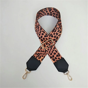 Macro shot of adjustable leopard print strap with gold metal buckles and black leather ends