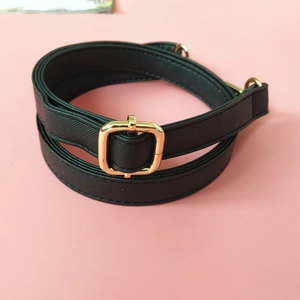 Close-up of black cross-grain leather bag strap with polished gold adjustable buckle