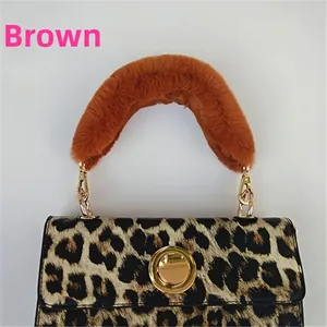 Detail of leopard print handbag with plush brown faux fur handle and gold metal twist lock