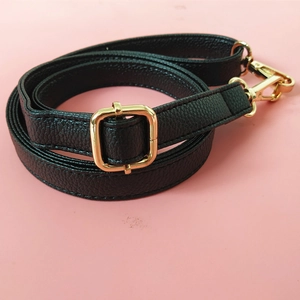 Detail of black litchi pattern PU leather strap with golden buckle and lobster clasps