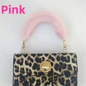 Detail of pink faux rabbit fur handle cover on leopard print bag with gold metal lock