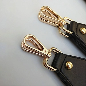 Adjustable black leather shoulder strap with gold lobster clasps and metal rivets for handbags