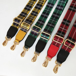 Adjustable wide canvas shoulder straps with tartan plaid pattern and gold hardware hooks