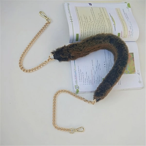Detailed view of plush brown faux fur shoulder strap with elegant gold metal chain and clasps