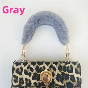 Detail of grey faux fur handle and leopard print bag with golden metal hardware