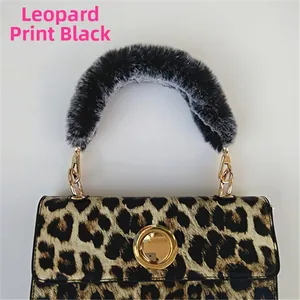 Detail of leopard print handbag with black faux fur handle and gold metal twist lock