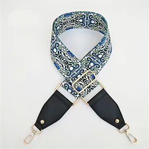 Close-up of geometric ethnic pattern bag strap with gold metal hardware and leather ends