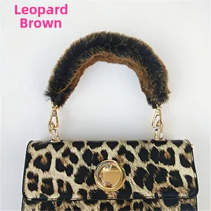 Detail of leopard print handbag with brown faux fur handle and golden metal buckle