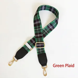Detail view of green plaid adjustable shoulder strap with gold-tone metal buckles