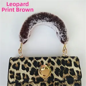 Detail of leopard print handbag featuring a soft coffee faux fur handle and gold metal lock