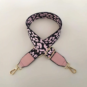 Détail de la bandoulière léopard rose avec crochets dorés et accents en cuir fin