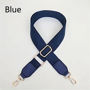 Detail of adjustable blue canvas strap with gold metal hooks and reinforced faux leather ends