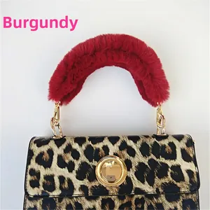 Close-up of wine red faux fur plush handle with gold spring buckles on leopard print bag