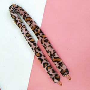 Close-up of leopard print faux fur bag strap with high-quality golden metal buckles