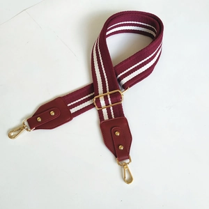Detail view of adjustable burgundy and white striped cotton purse strap with gold metal hooks