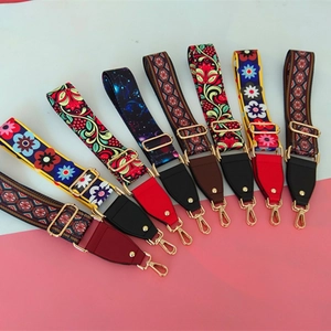 Close-up of adjustable ethnic pattern bag straps with gold metal hooks and leather ends