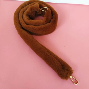 Close-up of brown faux fur bag strap with gold metal lobster clasps for handbags