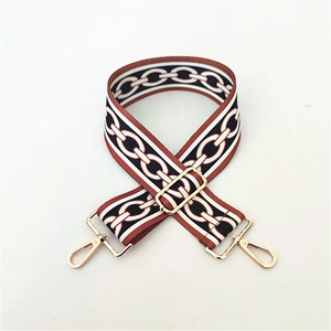 Close-up of adjustable ethnic crossbody strap with golden metal clasps and chain pattern