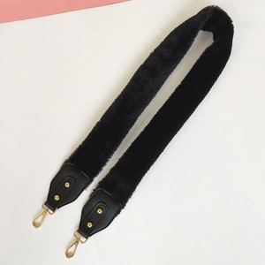 Detail of black faux fur shoulder strap with gold lobster clasps and leather ends