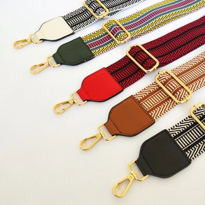 Detail view of five wide embroidered bag straps with colorful ethnic patterns and gold buckles