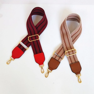 Detail of adjustable geometric woven bag straps with leather ends and gold metal clips