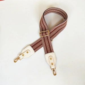 Adjustable brown and white geometric pattern strap with golden metal hooks for handbags
