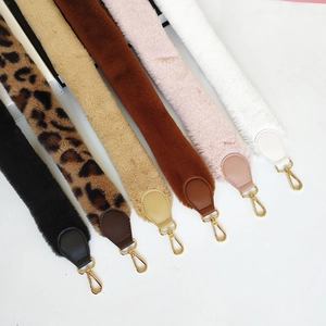 Macro detail of various faux fur shoulder straps with golden metal lobster clasps
