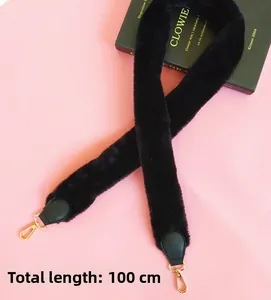 Detail of 100cm faux fur bag strap with gold metal hooks and black leather reinforced ends