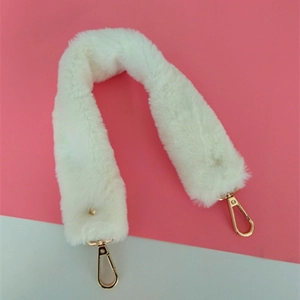 Détail d'une bandoulière en fausse fourrure blanche avec fermoirs mousquetons dorés