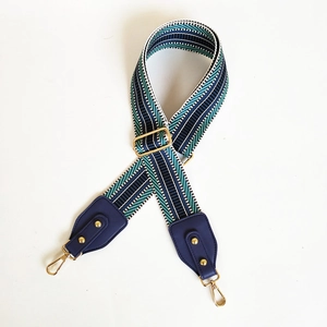 Close-up of adjustable woven shoulder strap with green and blue geometric pattern