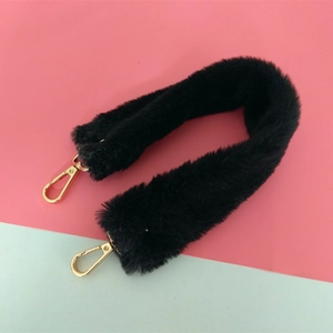 Détail de la bandoulière en fausse fourrure noire avec mousquetons dorés pour sacs à main