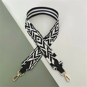 Close-up of ethnic geometric black and white woven shoulder strap with gold lobster clasps