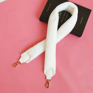 Detail view of soft white faux fur handbag strap with gold lobster clasps and leather tips