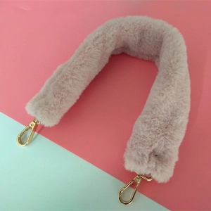 Détail de la bandoulière en fausse fourrure rose avec fermoirs mousquetons dorés