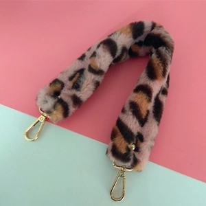 Détail de la bandoulière en fausse fourrure léopard rose avec mousquetons dorés
