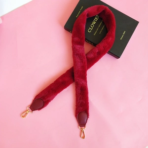 Detail of burgundy faux fur shoulder strap with gold metal lobster clasps and PU leather ends
