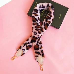 Detailed view of leopard print plush shoulder strap with golden lobster clasps and beige ends