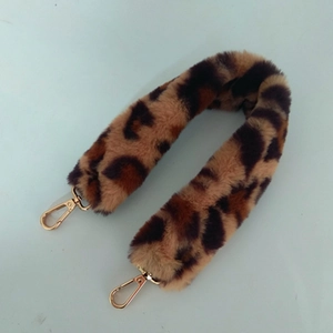 Détail de la bandoulière en fausse fourrure léopard avec mousquetons dorés