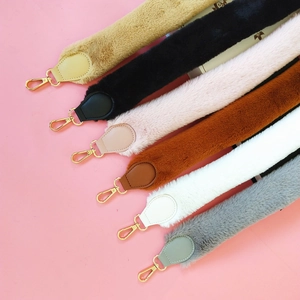 Detail of plush faux fur shoulder straps with leather ends and gold metal lobster clasps