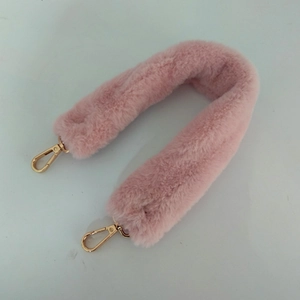 Détail de la bandoulière en fausse fourrure rose avec fermoirs mousquetons dorés