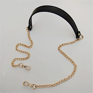 Detail of black PU leather shoulder strap with light gold metal chain and lobster clasps