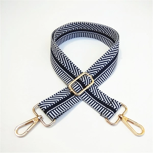 Detail of navy blue and white striped fabric bag strap with golden metal swivel hooks