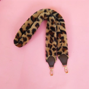 Detail of leopard print faux fur shoulder strap with brown leather ends and gold metal clasps