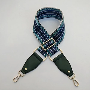 Détail de la bandoulière tissée bleu et vert avec fermoirs mousquetons en métal doré