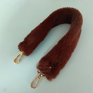 Détail de la bandoulière en fausse fourrure marron avec mousquetons dorés et doux